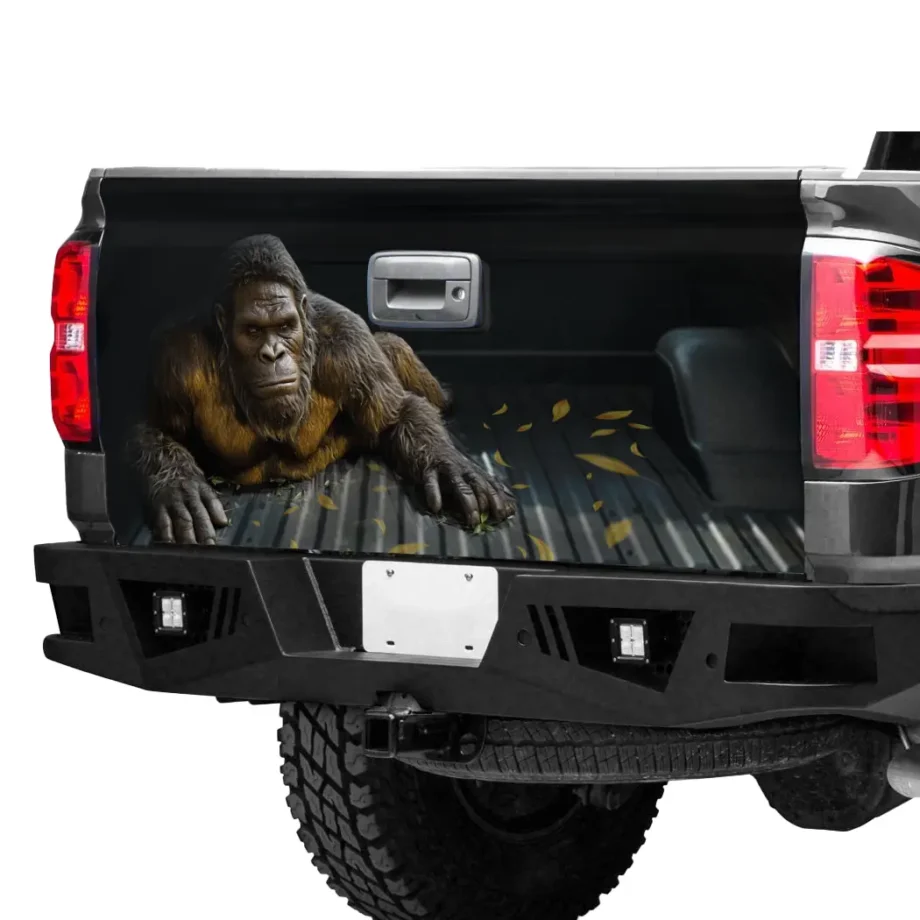 Bigfoot crawling tailgate wrap featuring Sasquatch with lifelike fur and leaves for outdoor truck decor