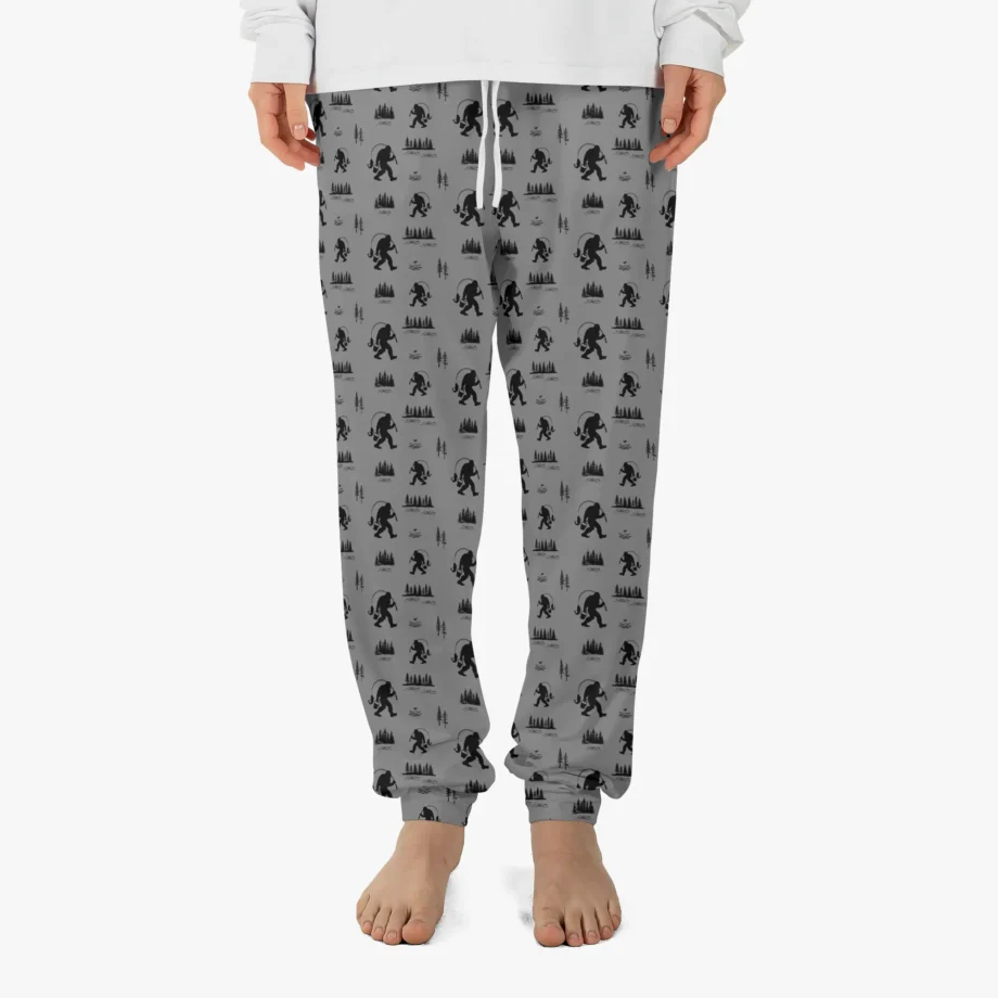 Bigfoot lounge pants with fishing theme and Sasquatch silhouettes on green fabric