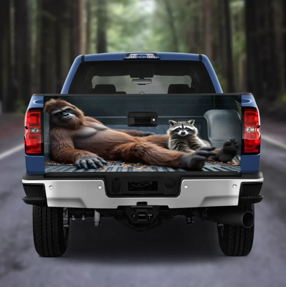 Funny Sasquatch truck tailgate wrap with Bigfoot and raccoon lounging for car decor