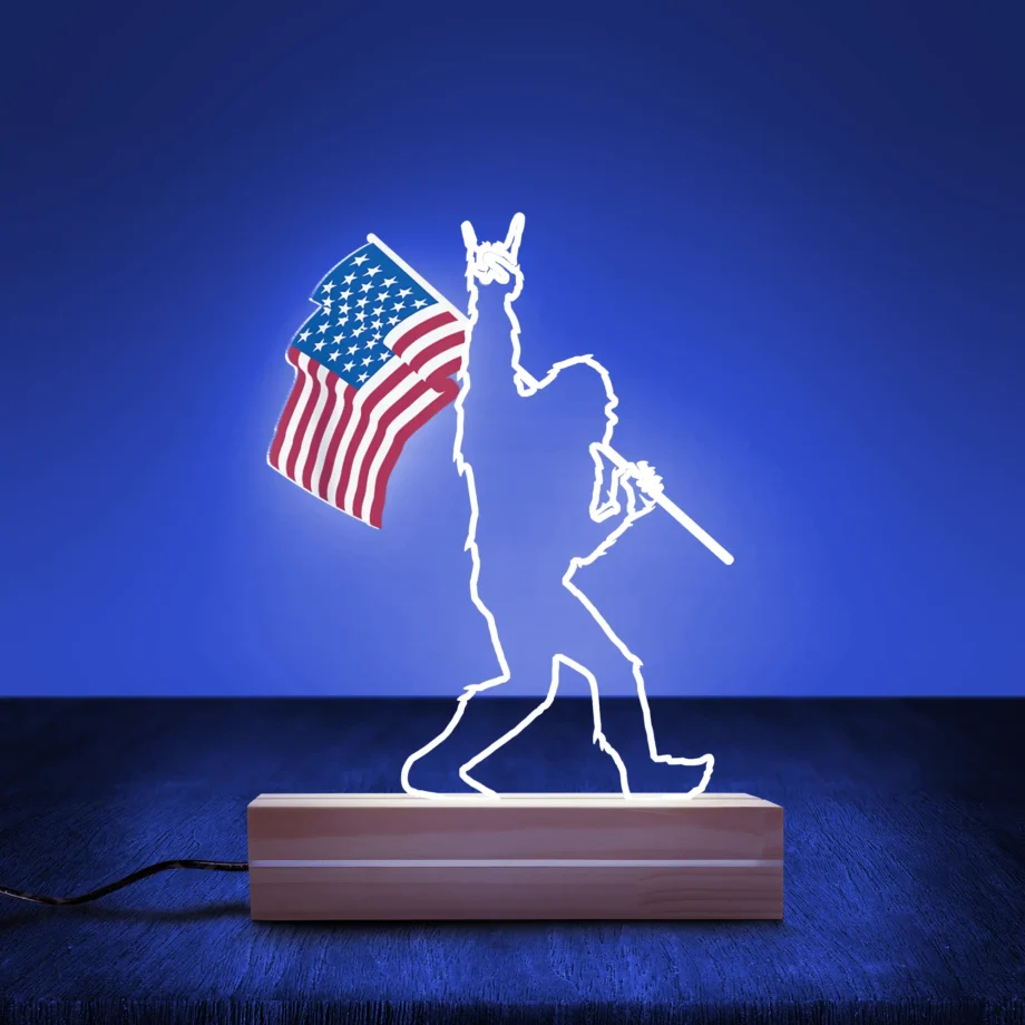 Rock Roll Bigfoot flag night light featuring Sasquatch holding an American flag with rock hand gesture