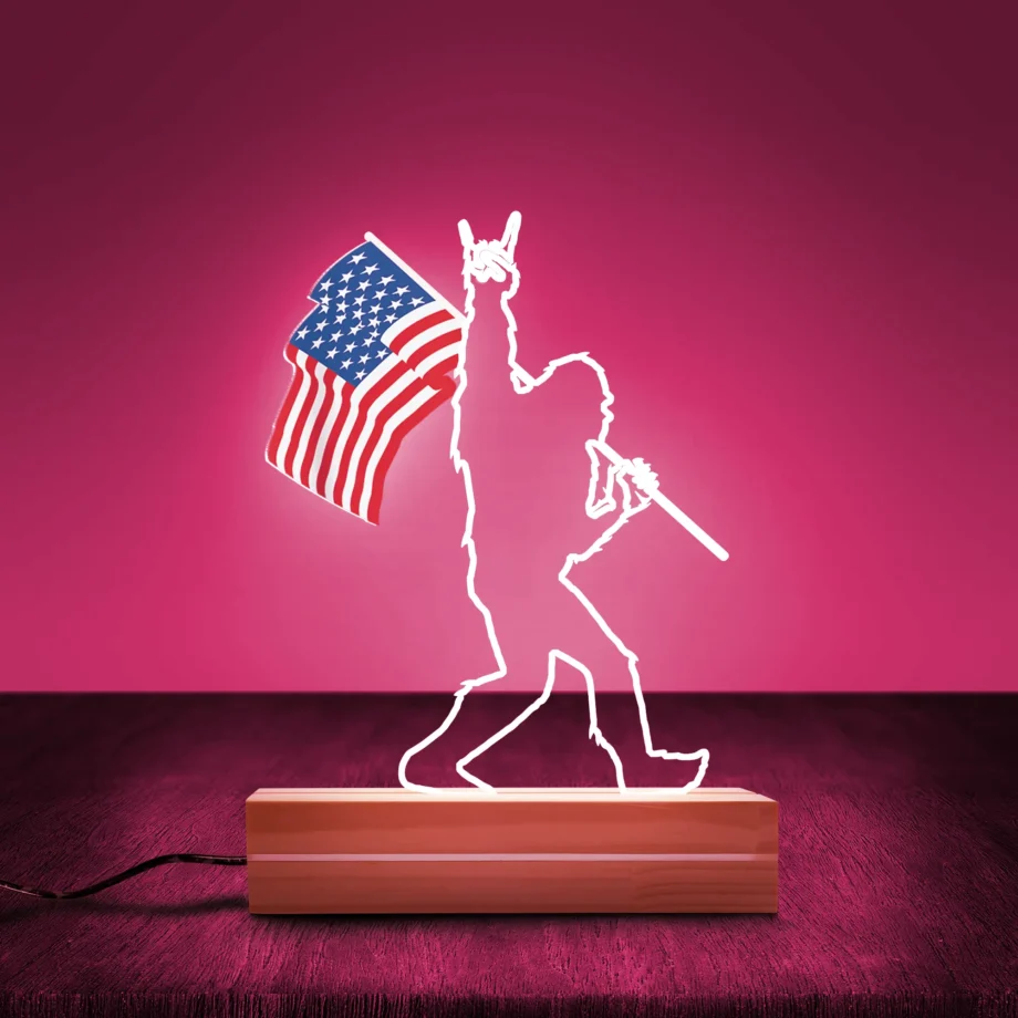 Bigfoot LED night light with Sasquatch holding an American flag and rock hand gesture design